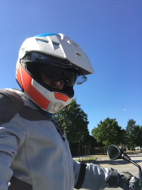 Author wearing motorcycle helmet and gray Klim jacket.
