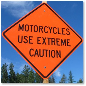 Motorcycles use extreme caution orange sign